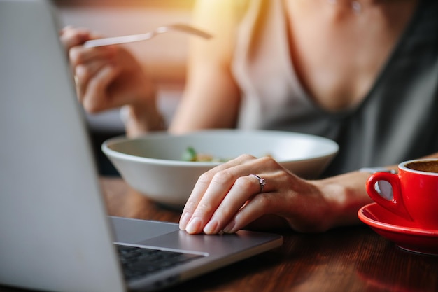 La donna sta lavorando in un caffè sul suo computer portatile Angolo basso