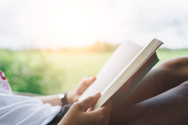 La donna sta leggendo il libro nel bellissimo parco e stagno rilassarsi e sfondo ambiente tranquillo.