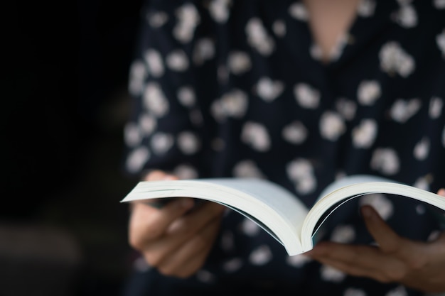 La donna sta leggendo un libro nel bellissimo parco e nello stagno rilassati e in un ambiente tranquillo