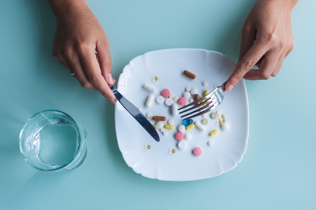 La donna sta mangiando pillole e droghe Concetto di dieta alimentare sana