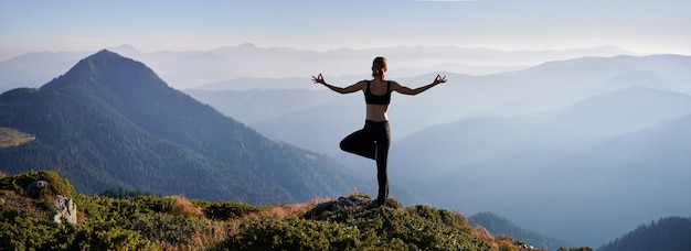 La donna sta praticando lo yoga nelle montagne di sera