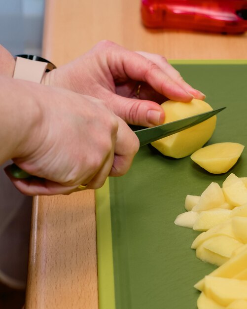 La donna sta preparando la cena Una donna taglia le verdure con un coltello Cucina Cucina