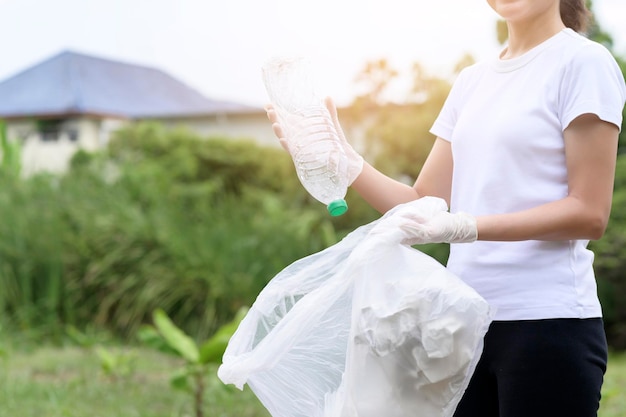 La donna sta raccogliendo spazzatura di riciclaggio sul concetto sostenibile ecologico a terra