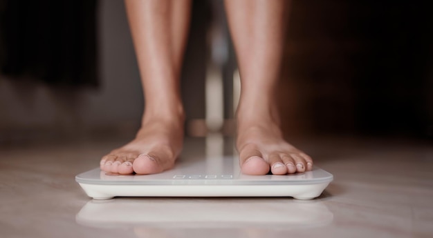 La donna sulla bilancia misura il peso Dieta femminile che controlla la perdita di peso di BMI