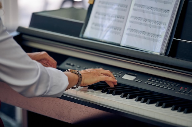 La donna suona il piano elettrico durante le esibizioni musicali all'aperto vista ravvicinata per mani agili