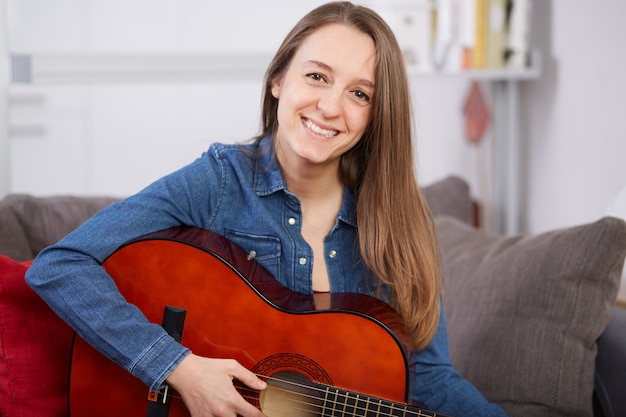 La donna suona la chitarra a casa