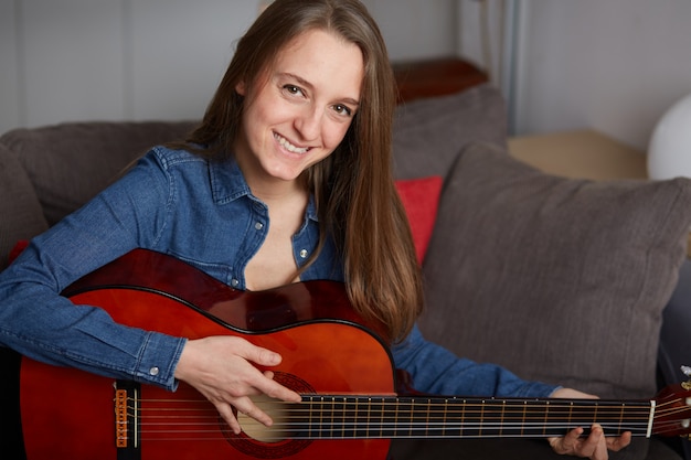 La donna suona la chitarra a casa