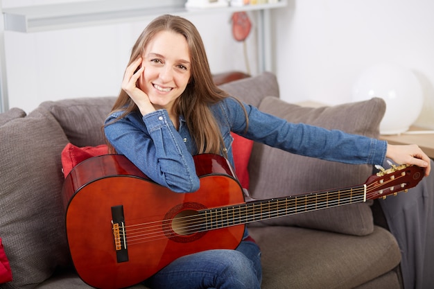 La donna suona la chitarra a casa