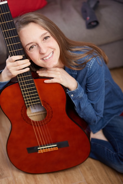 La donna suona la chitarra a casa