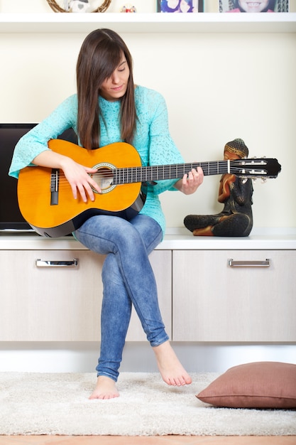 La donna suona la chitarra a casa