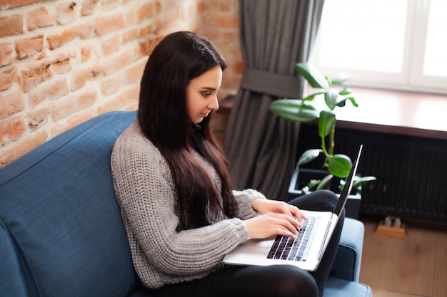 La donna sveglia resta a casa e lavora al computer portatile