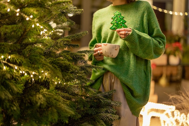 La donna tiene il pan di zenzero a forma di albero di Natale