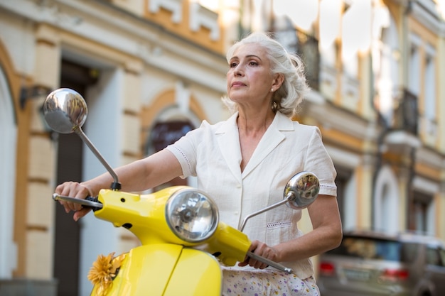 La donna tiene il volante del motorino.