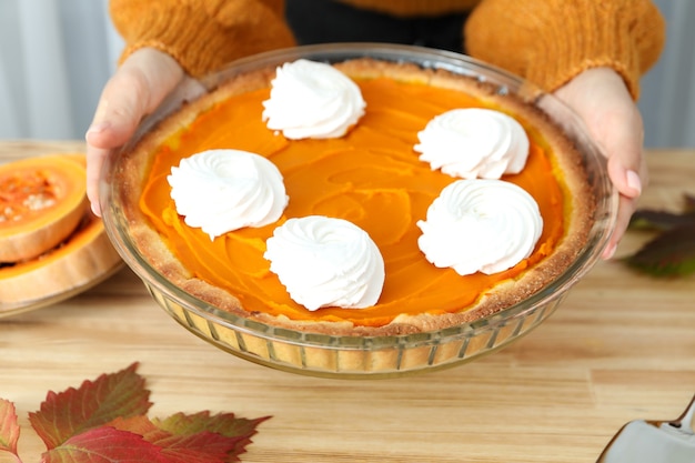 La donna tiene in mano la torta di zucca, primo piano