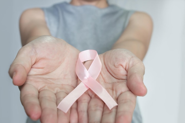 La donna tiene in mano un fiocco rosa per incoraggiare i malati di cancro al seno e sostenere la campagna contro il cancro al seno in ottobre