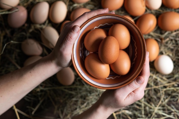 La donna tiene in mano una ciotola di uova di gallina fatte in casa Cibo sano