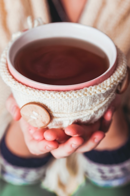 La donna tiene in mano una tazza di tè caldo