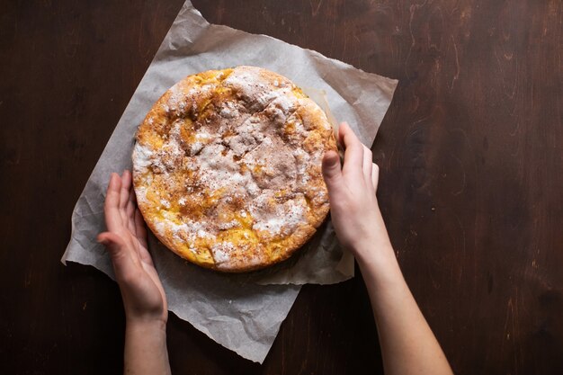 La donna tiene la torta fresca con mele e cannella