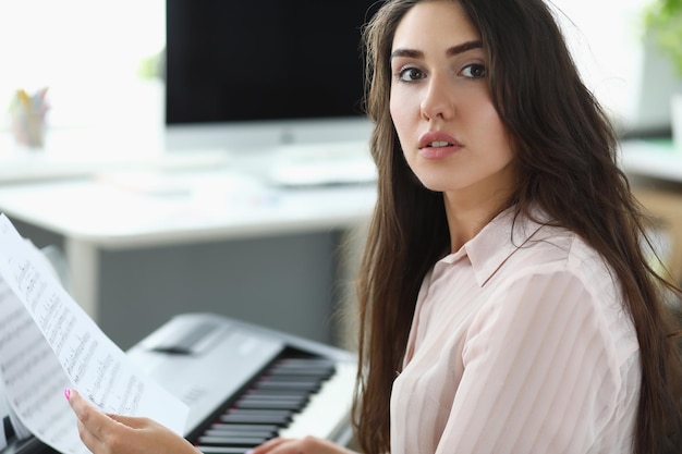 La donna tiene note musicali e suona il sintetizzatore domestico