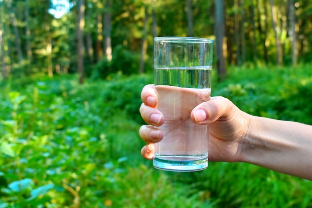 La donna tiene un bicchiere di acqua pulita all'aperto