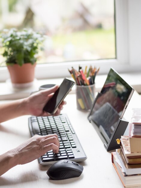 La donna tiene un telefono telelavoro dal concetto di casa