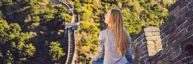 La donna turistica allegra e gioiosa felice alla grande muraglia cinese medita sul viaggio di vacanza nella ragazza dell'asia