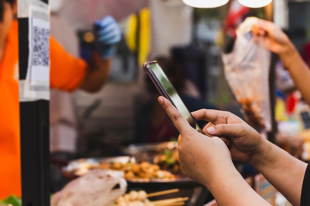 La donna usa lo smartphone scansiona il codice QR nel negozio di alimentari