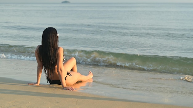 La donna viaggia da sola sulla spiaggia al tramonto. Stile di vita all'aperto da solista durante le vacanze estive.