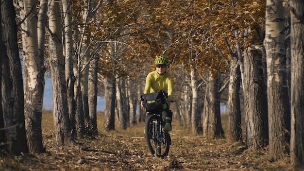 La donna viaggia su terreno misto cicloturismo con bikepacking. Il viaggio del viaggiatore con le borse della bicicletta. Bikepacking da turismo sportivo.