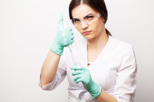 La dottoressa in maschera medica prende la siringa per fare un'iniezione