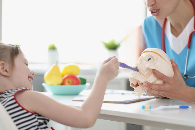 La dottoressa lascia che la paziente della bambina giochi con un teschio di plastica finto