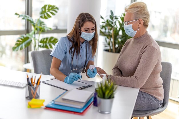 La dottoressa misura la temperatura della donna senior