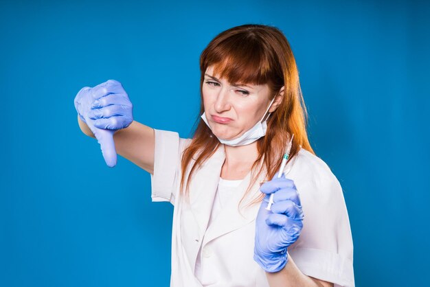 La dottoressa mostra il pollice verso il basso nella maschera medica