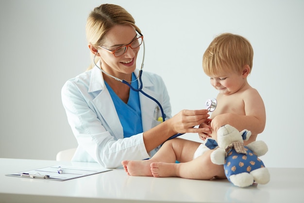 La dottoressa sta ascoltando un bambino con uno stetoscopio in clinica