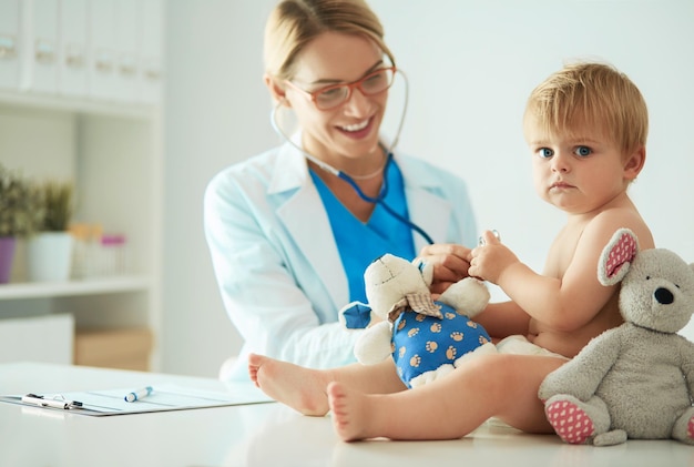 La dottoressa sta ascoltando un bambino con uno stetoscopio in clinica