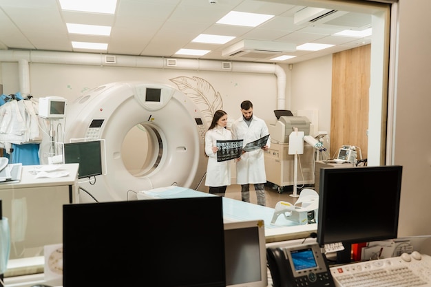 La dottoressa stagista sta studiando nella sala di scansione della tomografia computerizzata TC ai corsi di tirocinio Medici colleghi discutono di raggi X nella sala di scansione della tomografia computerizzata TC