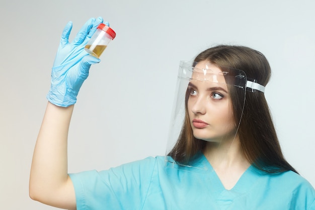 La dottoressa tiene in mano una bottiglia di test delle urine