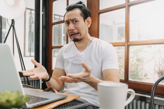 La faccia buffa e scioccata dell'uomo delude il suo lavoro nel suo laptop in