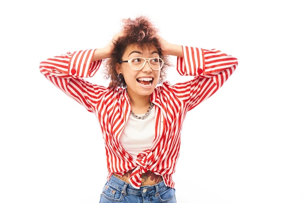 La faccia scioccata della ragazza kazaka con riccioli afro che tiene la testa con le mani sembra sorpresa sullo sfondo bianco dello studio con spazio per la copia