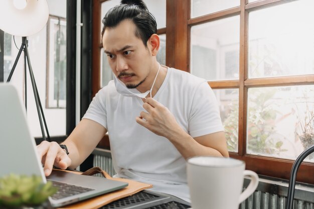 La faccia seria dell'uomo si concentra sul suo lavoro nel laptop