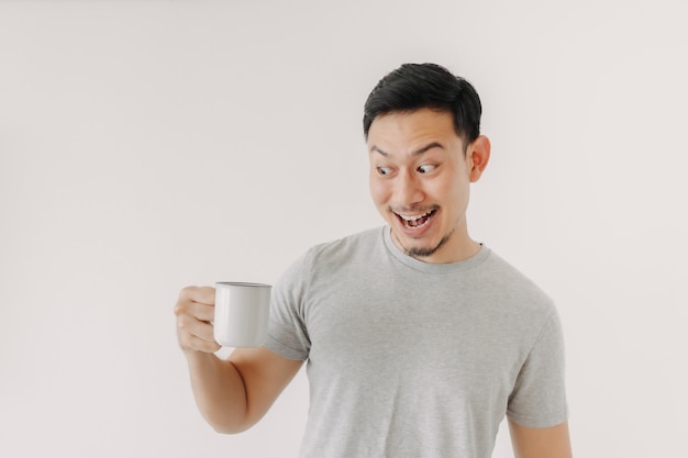 La faccia sorpresa dell'uomo beve una tazza di caffè isolata su fondo bianco