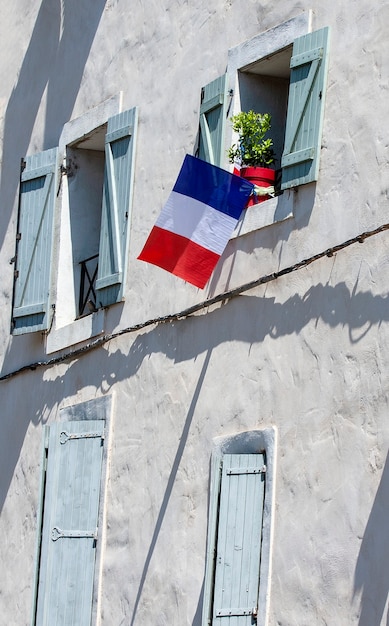 La facciata dell'edificio con le bandiere della Francia nella finestra.