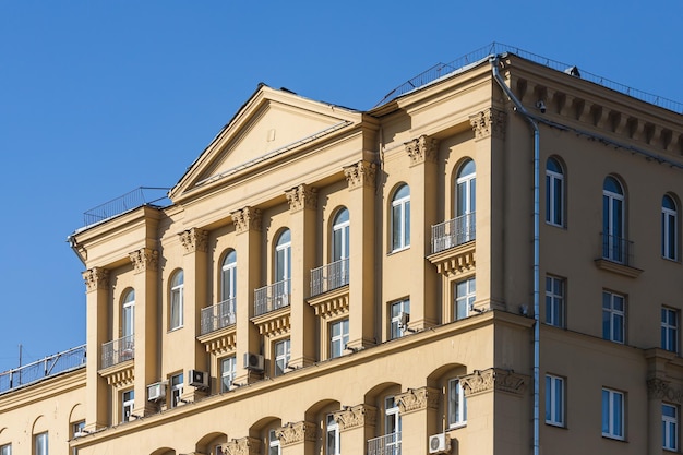 La facciata è un classico edificio in pietra gialla con finestre arrotondate, colonne e balcone in ferro battuto. architettura sovietica