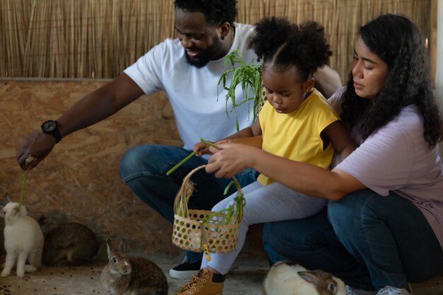 La famiglia asiatica e afroamericana si riposa in vacanza portando i bambini allo zoo