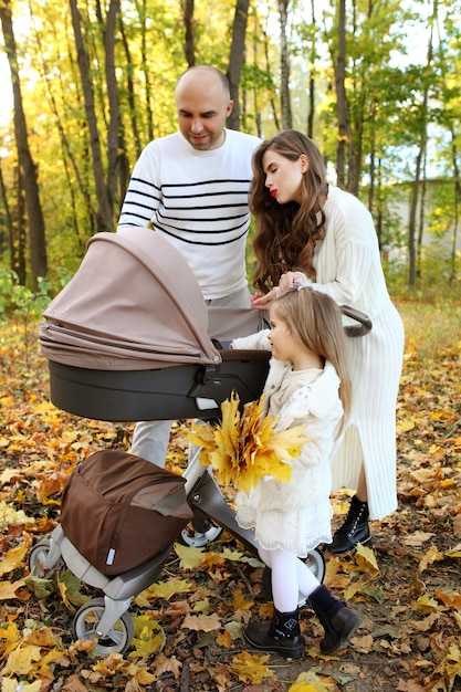 La famiglia cammina sulle foglie d'autunno