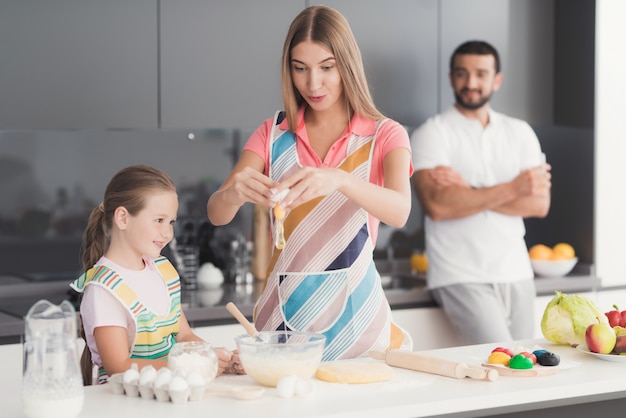 La famiglia cucina l'impasto per la cottura.