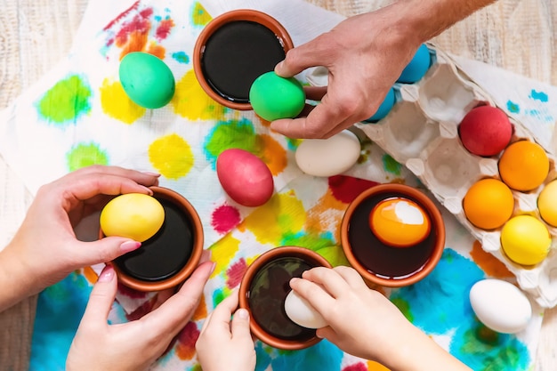 La famiglia dipinge le uova di Pasqua. Messa a fuoco selettiva celebrazione.