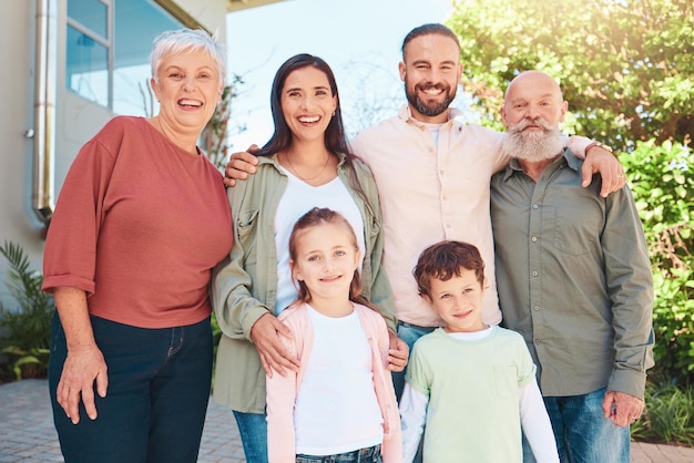 La famiglia è felice all'aperto nel ritratto con la felicità delle generazioni con i nonni genitori e bambini in giardino Le persone insieme a casa per le vacanze estive sorridono e legano con amore e cura