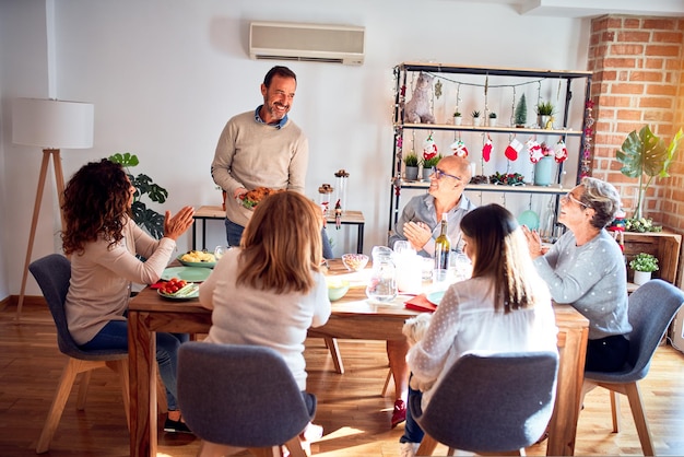 La famiglia e gli amici cenano a casa festeggiando la vigilia di natale con cibo e decorazioni tradizionali, mostrando l'orgogliosa cucina del tacchino