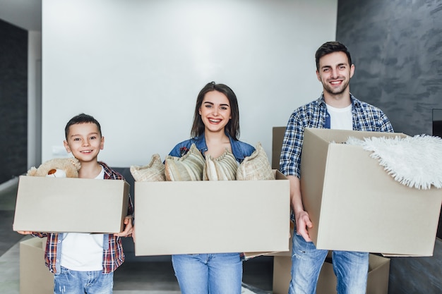 La famiglia entra in una nuova casa tenendo le scatole con le cose